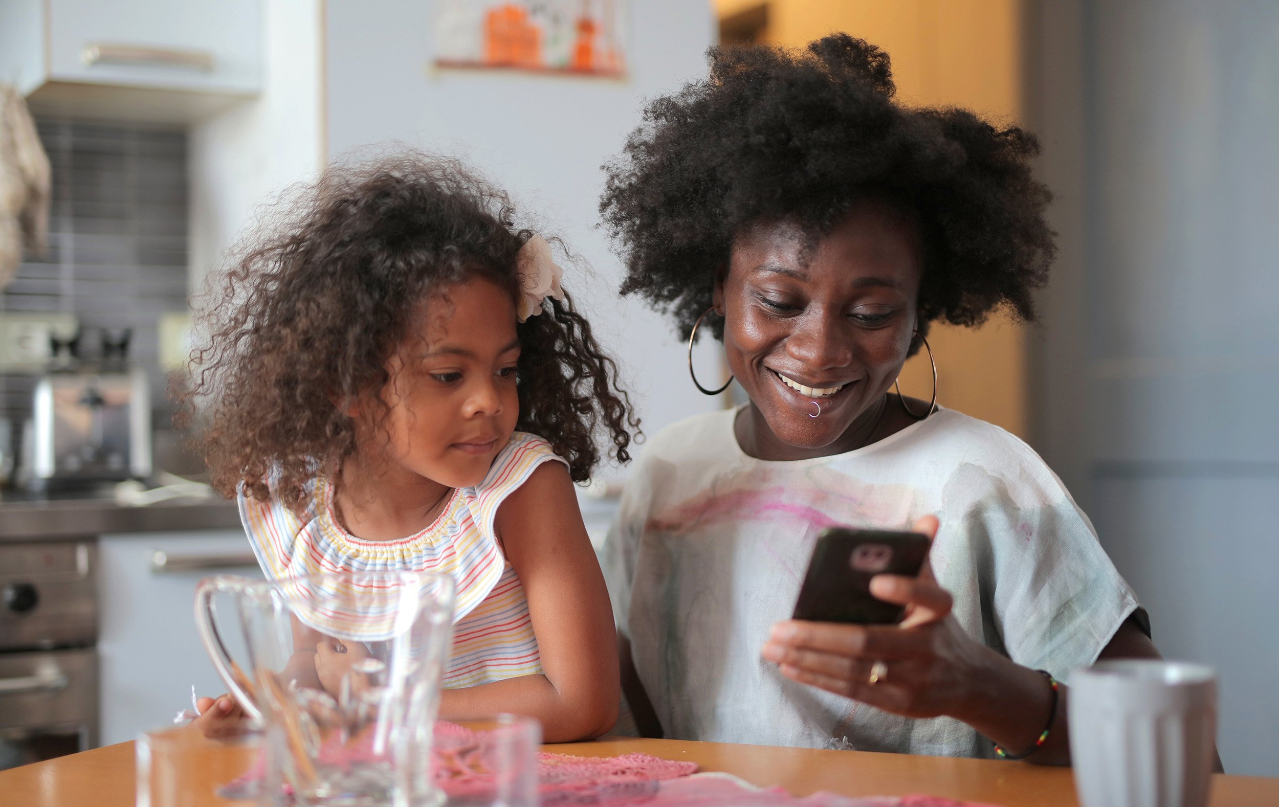 mother and daughter at the kitchen table on phone