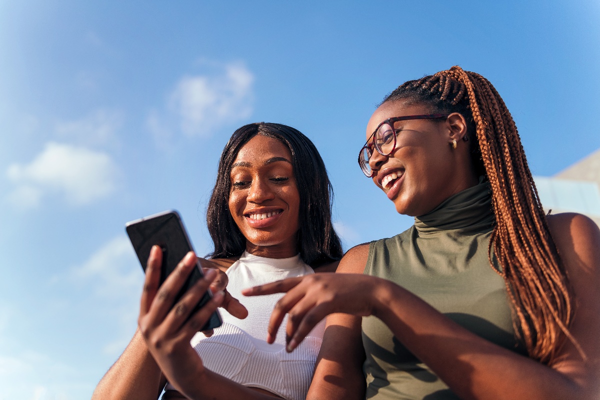 woman friends smiling looking at phone-1